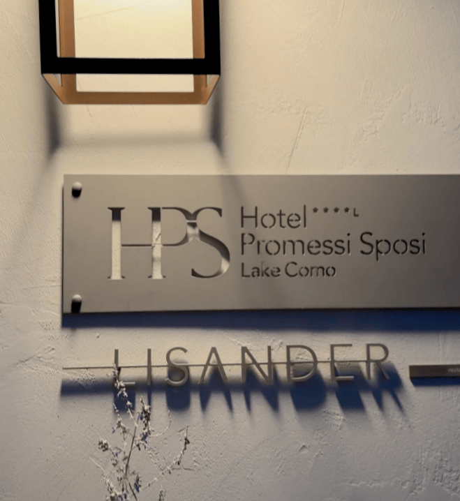 Signage for Hotel Promessi Sposi located at Lake Como, featuring the abbreviation 'HPS' and the name 'LISANDER'.